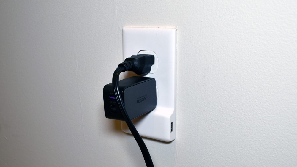 UGREEN Nexode 65W USB-C Charger plugged into a wall outlet